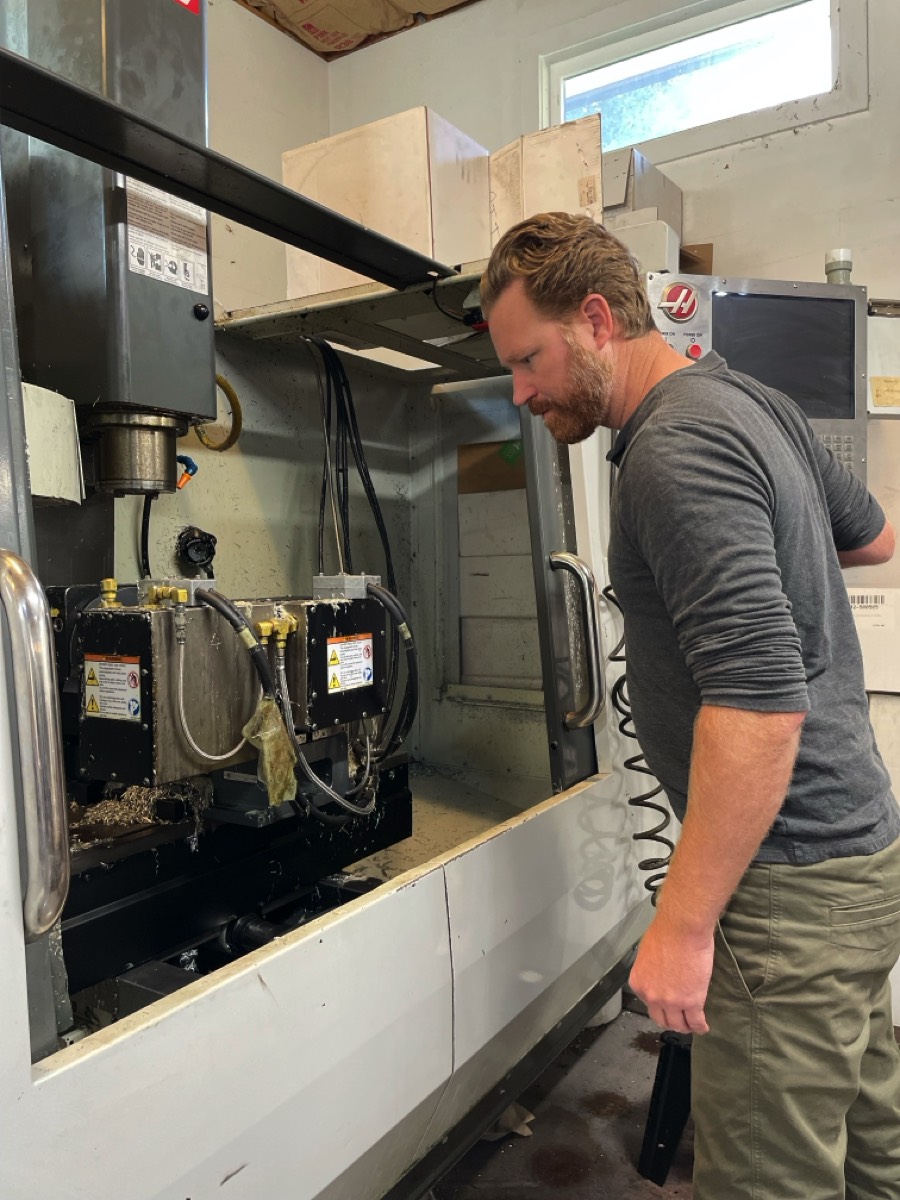 Jeff Hooper inspecting a 5-axis CNC mill with trunnion at Hooper Machine & Design in Chattanooga, TN
